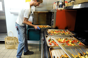 Nick Schneider prepares roasted vegetable skewers for The Return of King Idomeneo: A Picnic Operetta, 2012